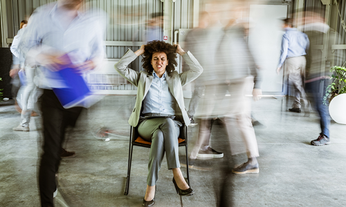 A woman sitting on a chair pulling at her hair