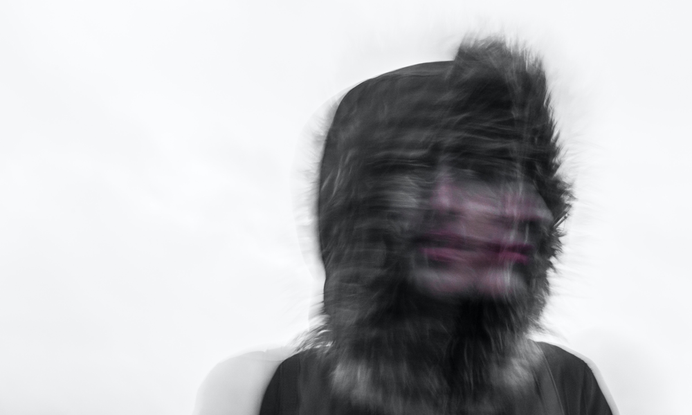 Blurred double exposure photo of a face hidden by hoodie