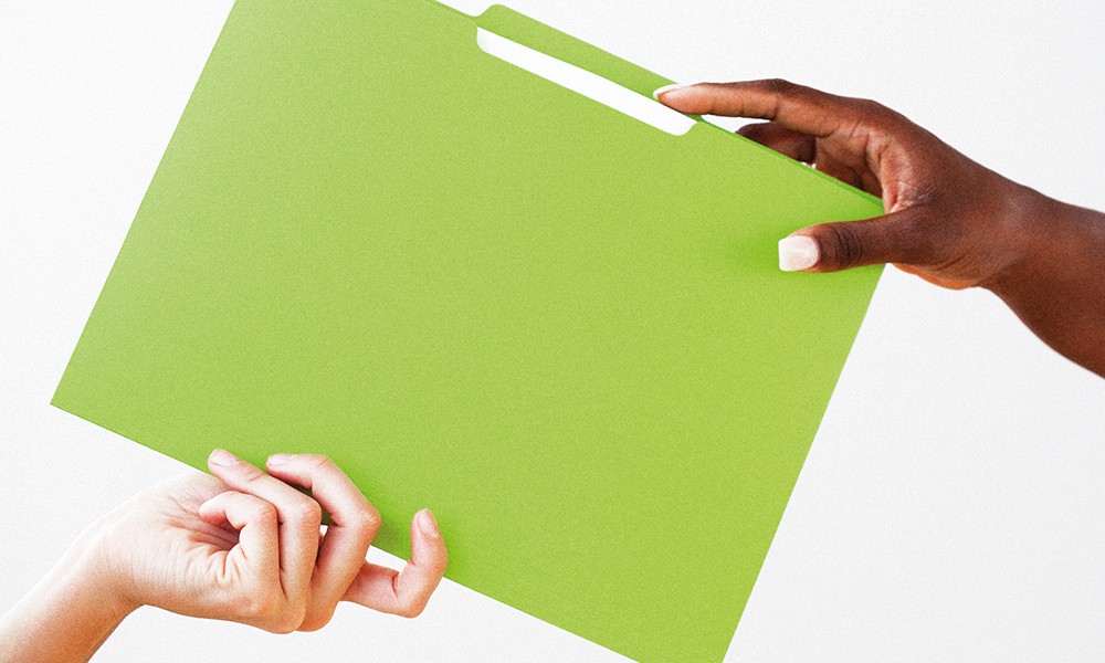 Hands passing green folder