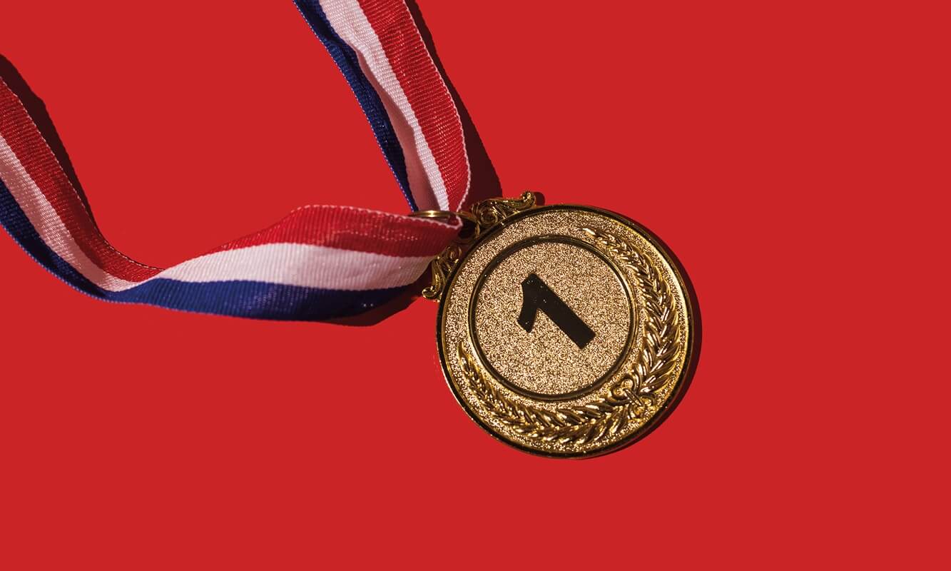 A winner's medal bearing the number one against a red background